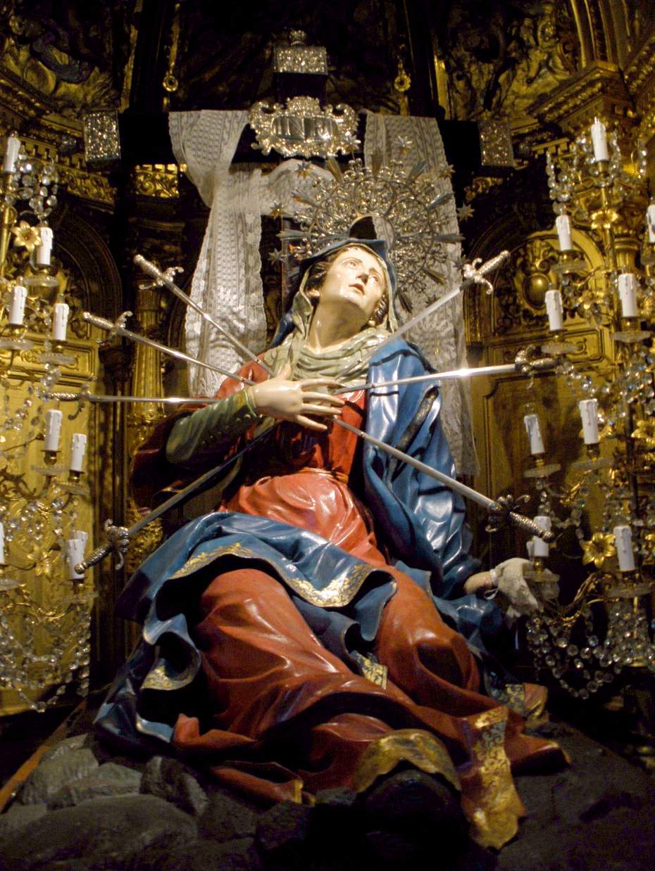 An image of Our Lady of Sorrows, reclining backwards, seven swords piercing her heart.